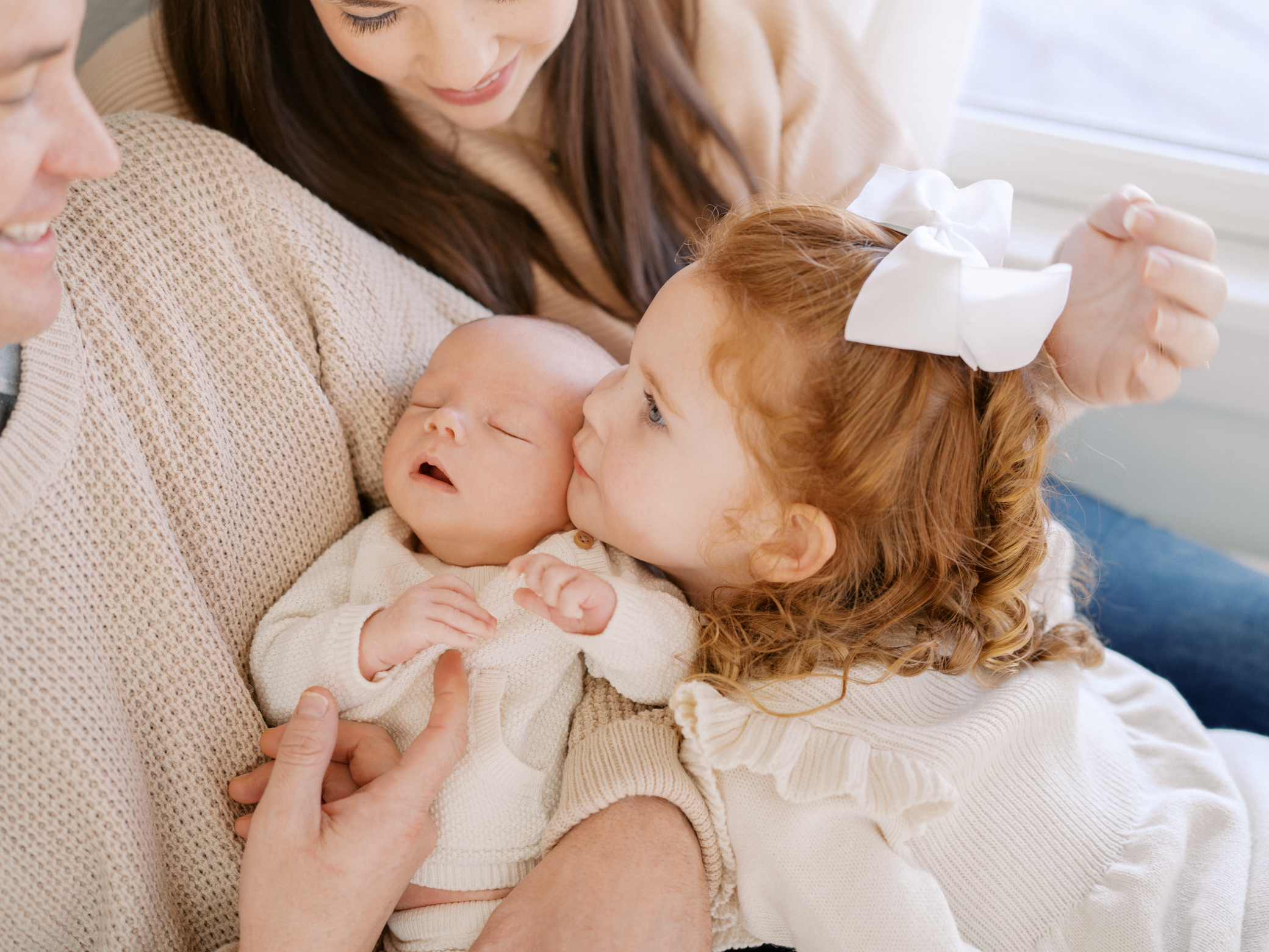 Kansas City newborn photographer photo of family and big sister snuggling baby brother at home